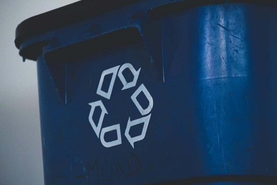 Blaue Mülltonne mit weißem Recycling Logo