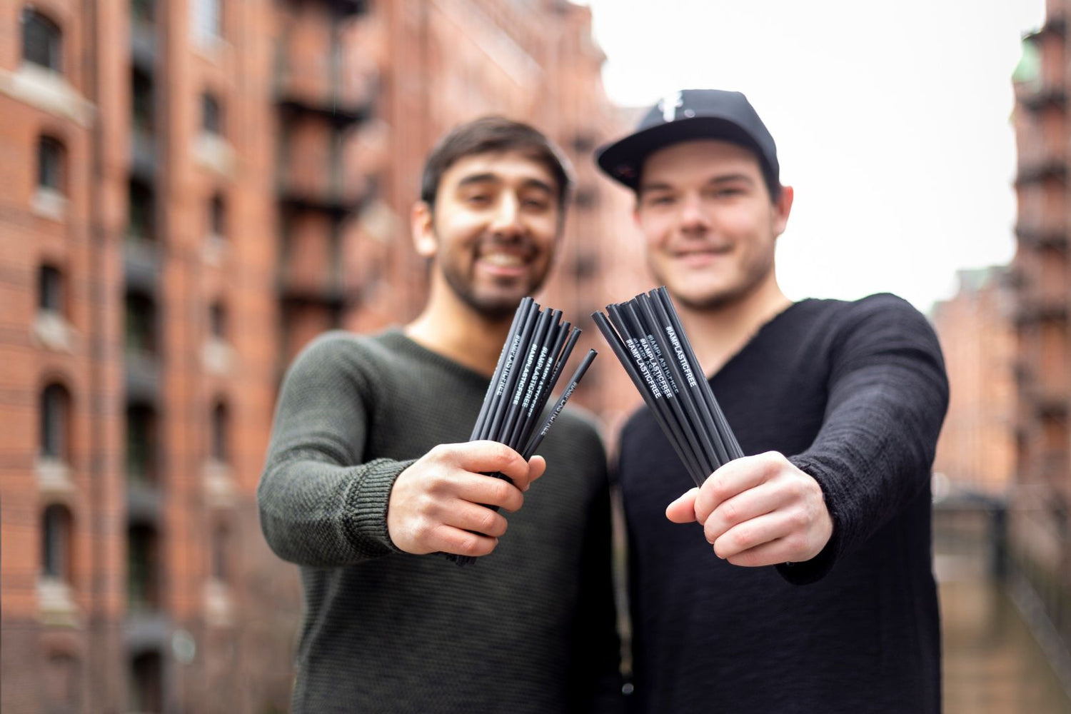 Gründer Daniel Knoeppel und Kevin Mata halten #IAMPLASTICFREE Trinkhalme 2.0 in Kamera