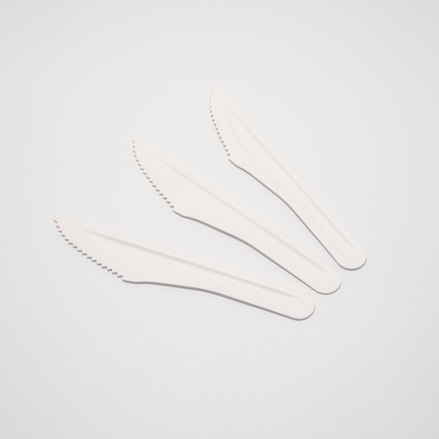 Drei unbeschichtete Messer aus Papier nebeneinander liegend